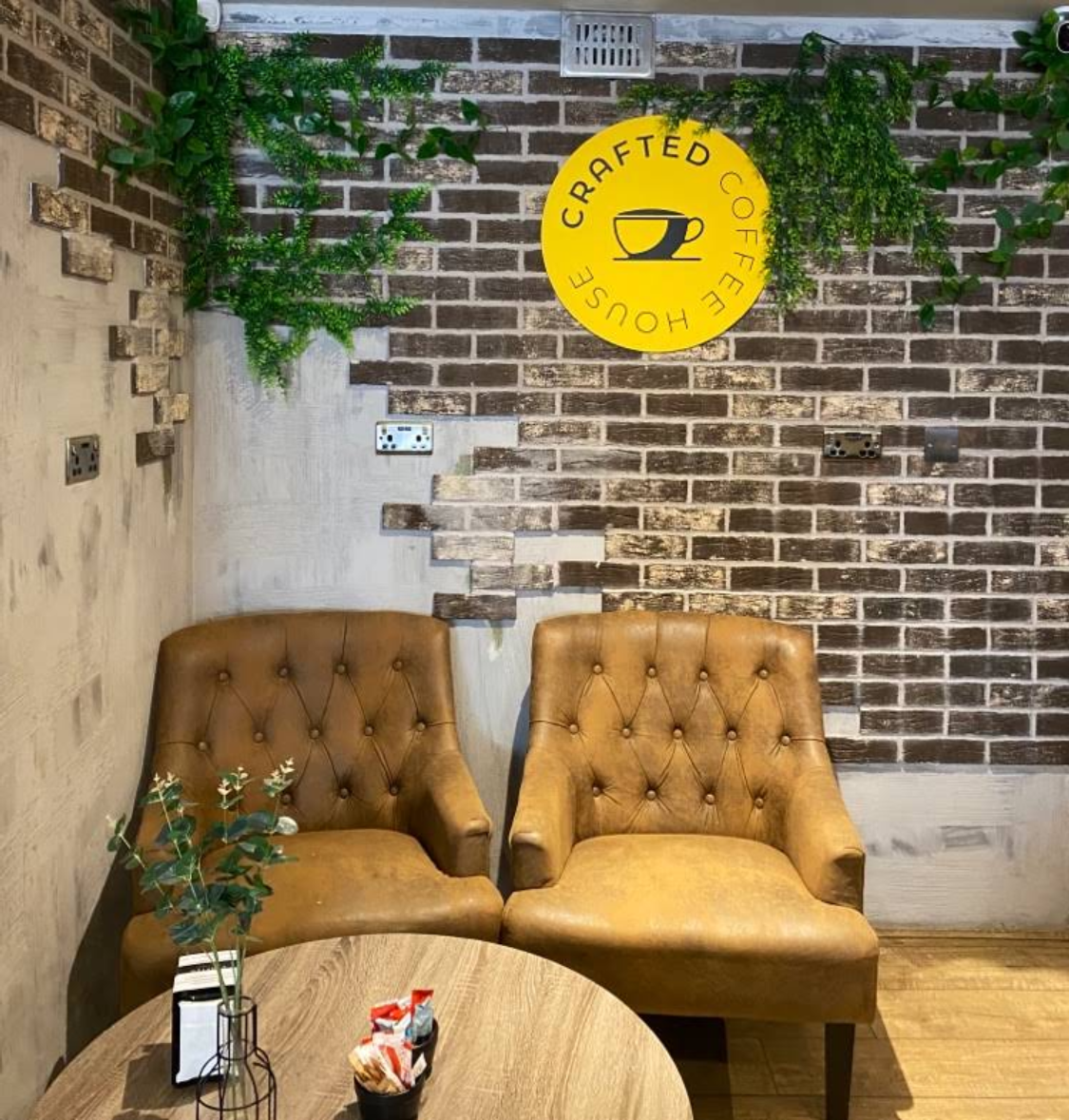 Cosy tan leather armchairs and round table seating area